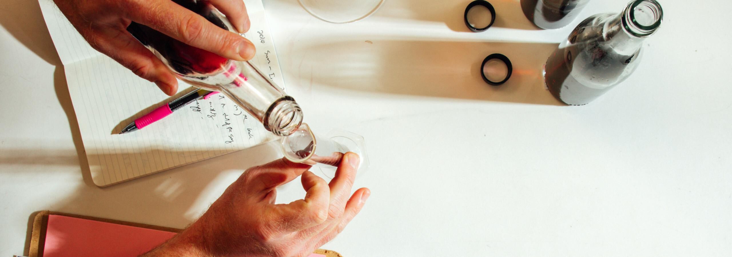 Overhead shot of a person blending wine in a lab Overhead shot of a person blending wine in a lab